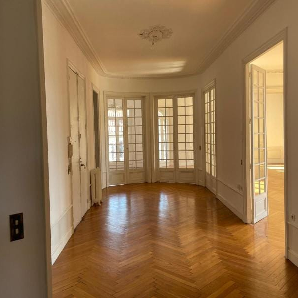 Piękne salon avec parquet chevronné et grandes portes-fenêtres.