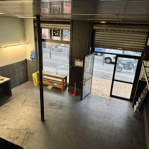 Intérieur d'un garage avec une porte d'accès sur rue et divers véhicules.