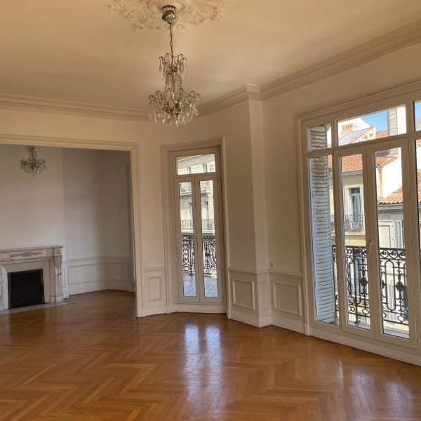 Belle pièce lumineuse avec parquet et moulures, idéale pour un salon élégant.