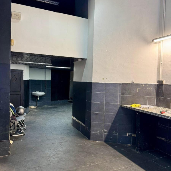 Espace intérieur sombre et usé avec des murs contrastés et un sol carrelé.