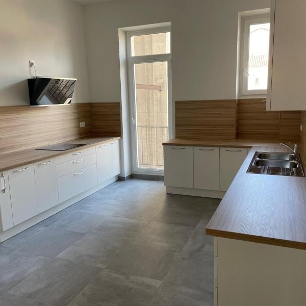 Cuisine moderne et lumineuse avec un îlot central et des armoires blanches.