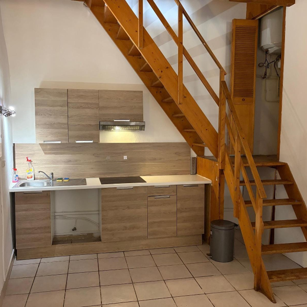 Cuisine d'un appartement avec une échelle intégrée et un espace de rangement.